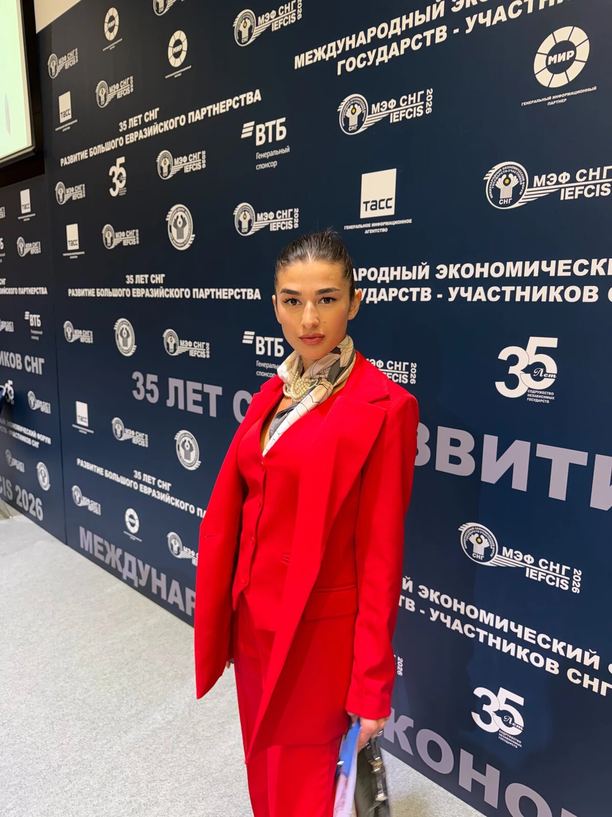 Standing in a red suit at an international economic forum